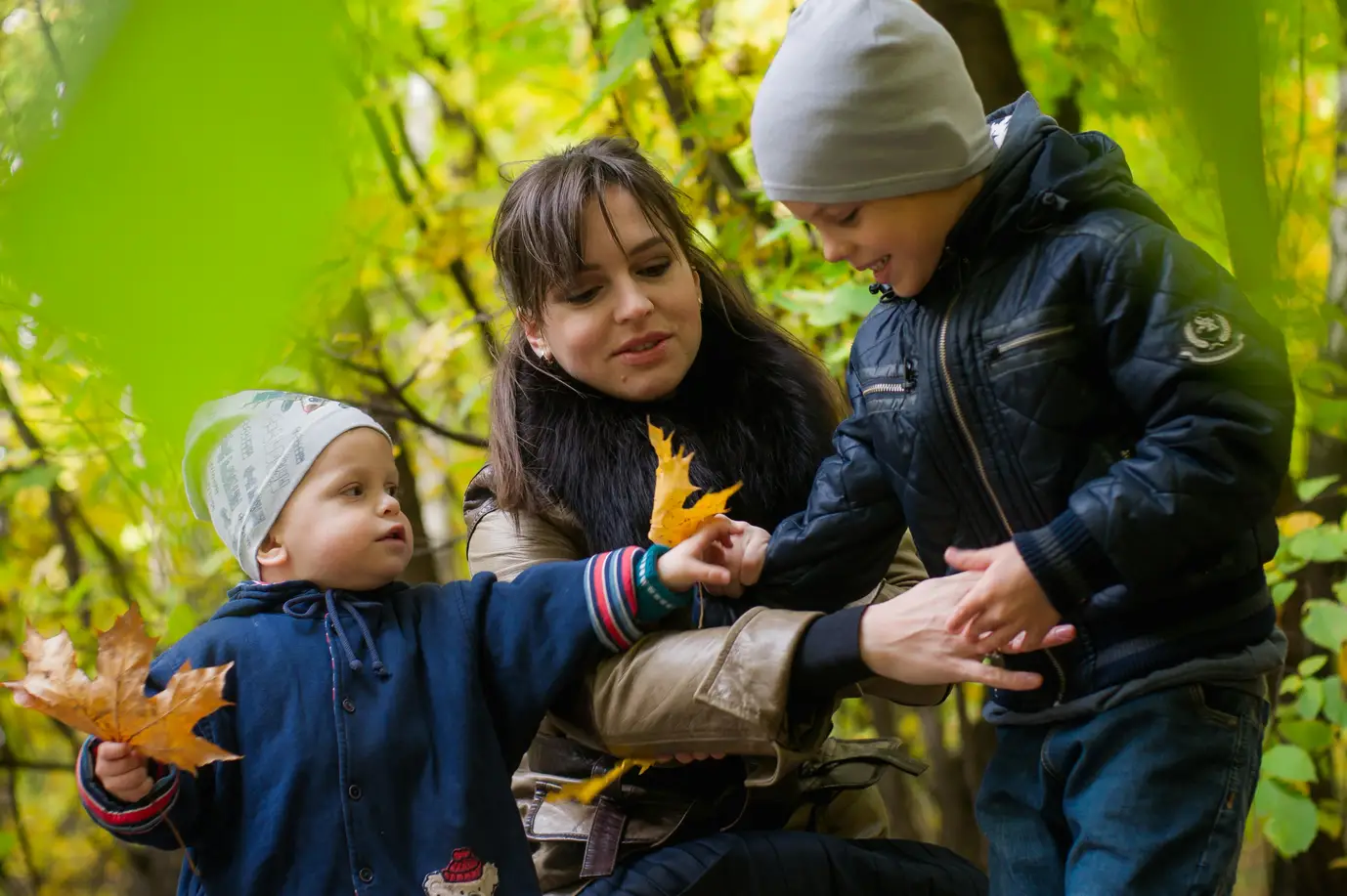 Mutter mit zwei Kindern im herbstlichen Wald